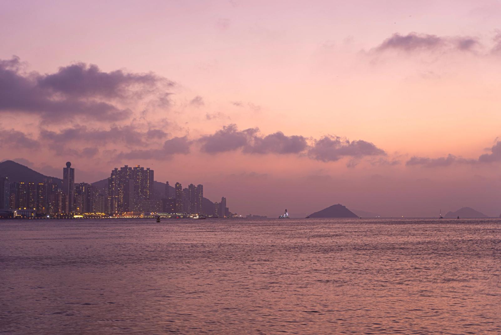 Breathtaking view of Hong Kong skyline and sea at twilight with illuminated buildings