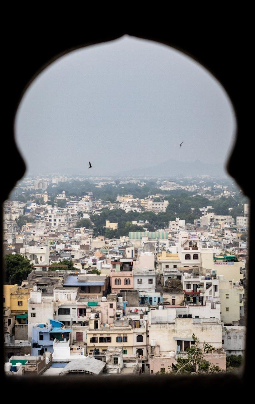 Explore the vibrant cityscape of Udaipur, Rajasthan, framed through a traditional arch