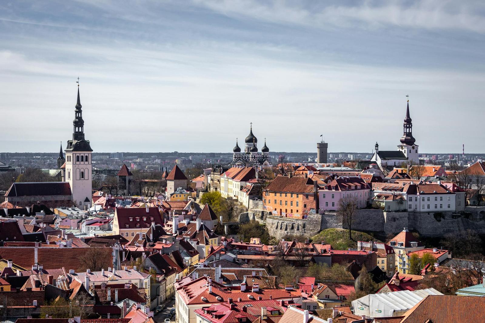 Old town rooftops and towers viewed from above under a pale sky