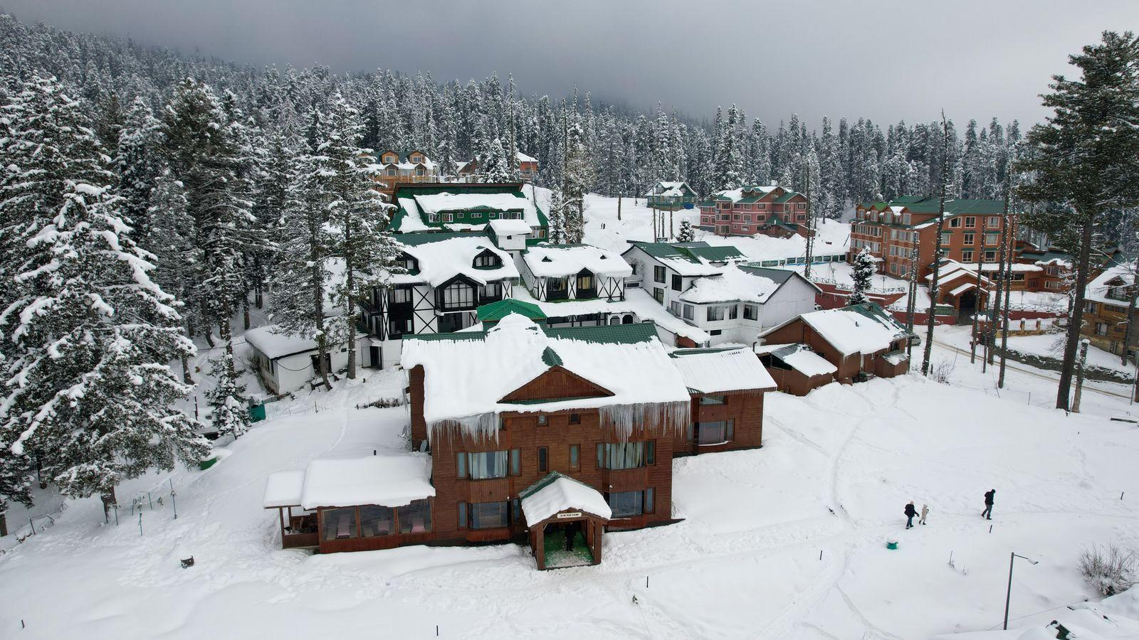 Snow-covered lodges among the pines at Gulmarg