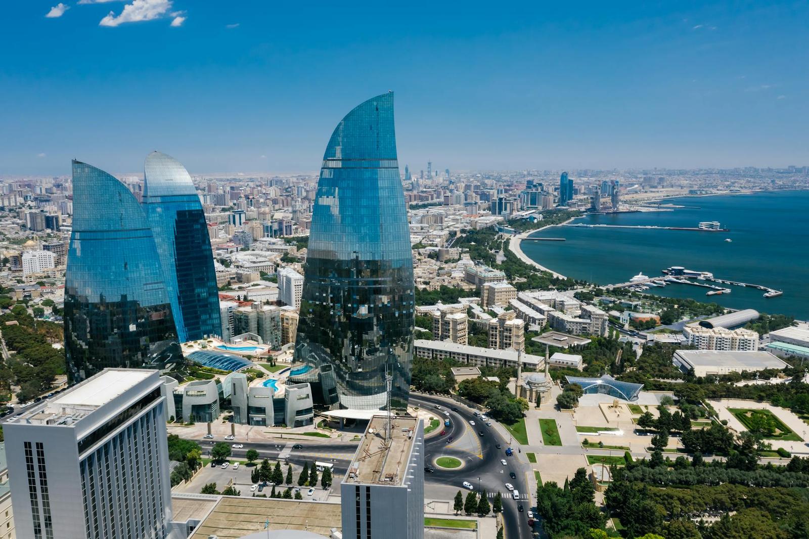 Aerial view of curved glass skyscrapers rising above a coastal city