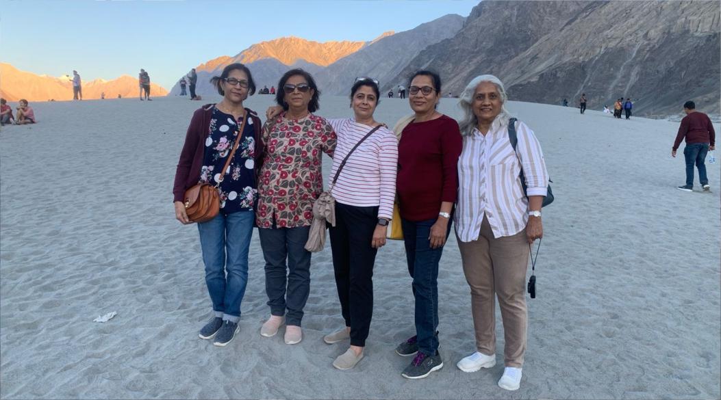 Five women posing together in a scenic desert landscape.