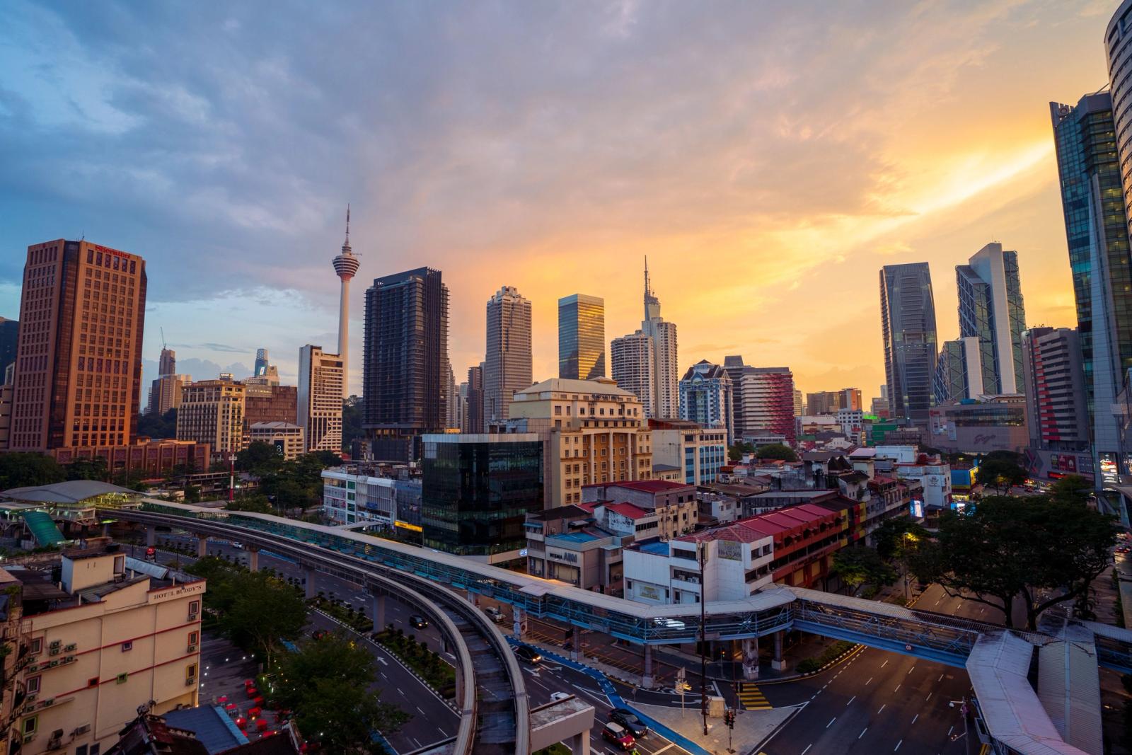 A breathtaking view of Kuala Lumpur's skyline at sunset, featuring the iconic KL Tower and vibrant cityscape