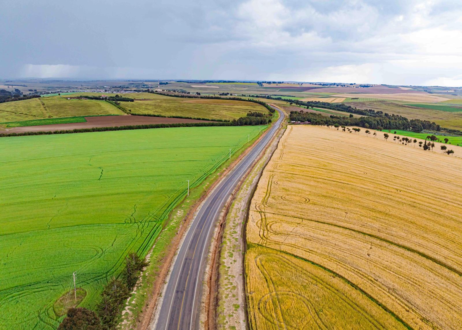 Vibrant aerial shot of farmlands and road in Mau Narok, Kenya on a cloudy day