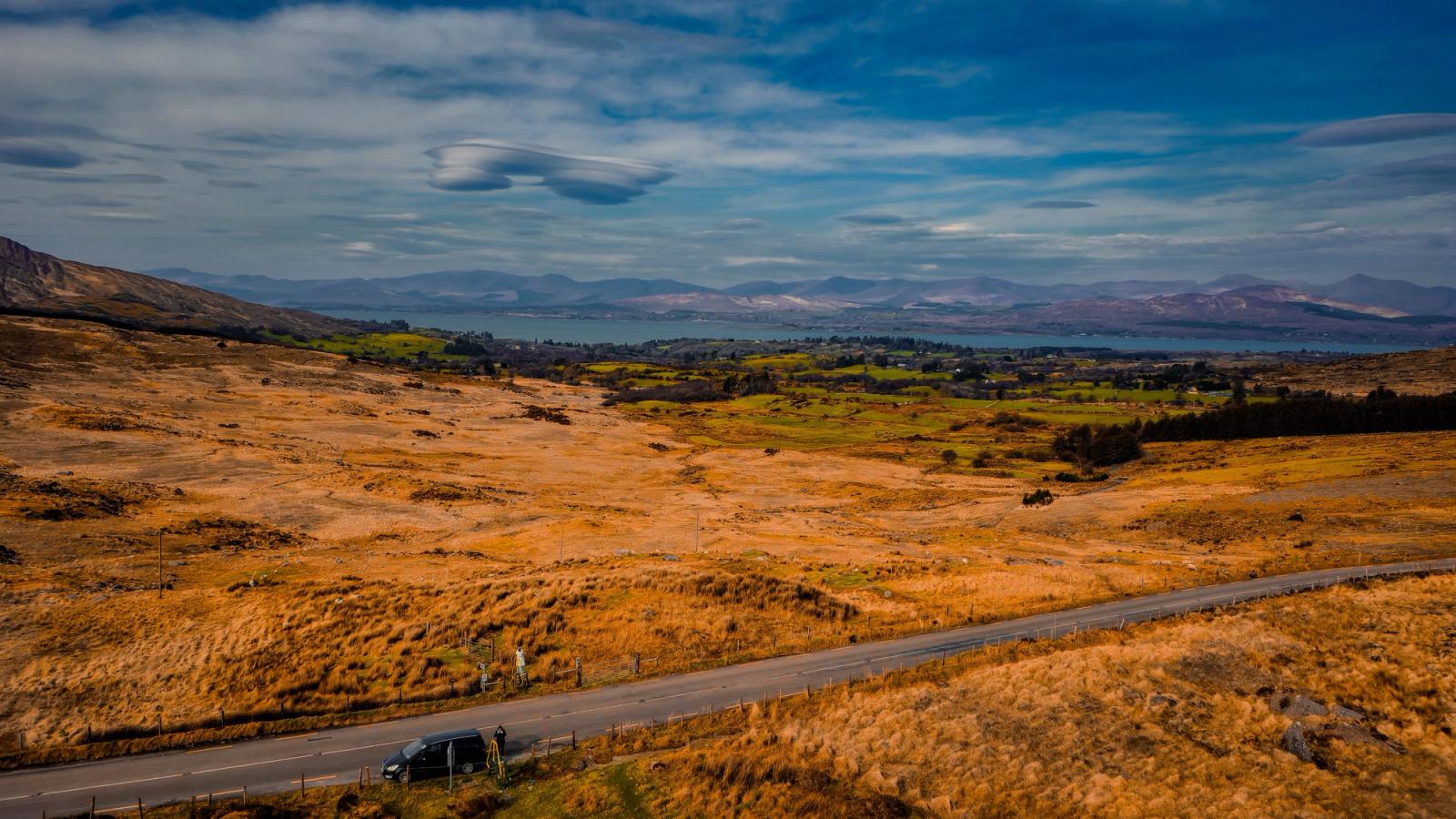 Stunning view of Ireland's natural landscape with mountains and road under a blue sky