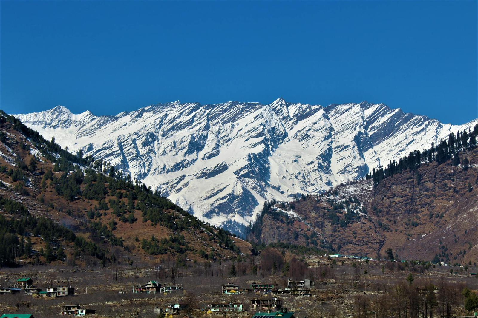 Stunning snow-covered mountains with settlements nestled in the valley below