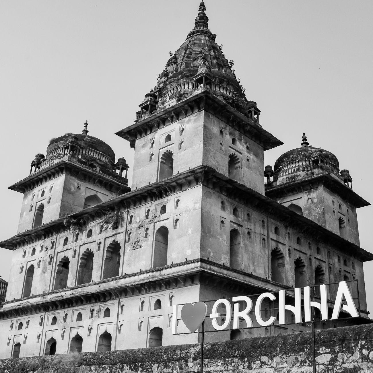 Tiered temple towers of Orchha rising behind an I love Orchha sign