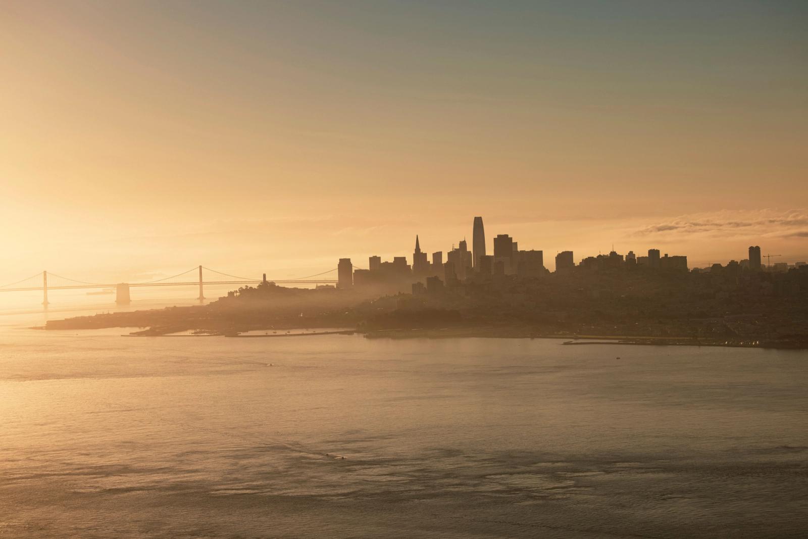 Sunset skyline of San Francisco with Golden Gate Bridge under a golden sky