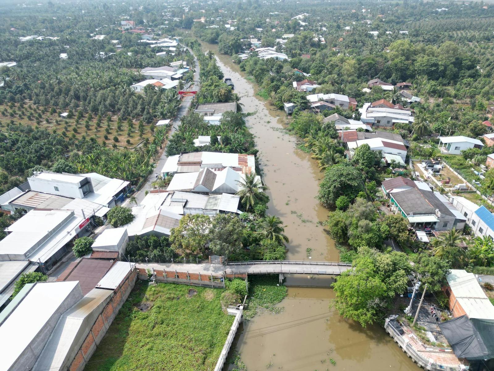Aerial view of a muddy river winding through a riverside village