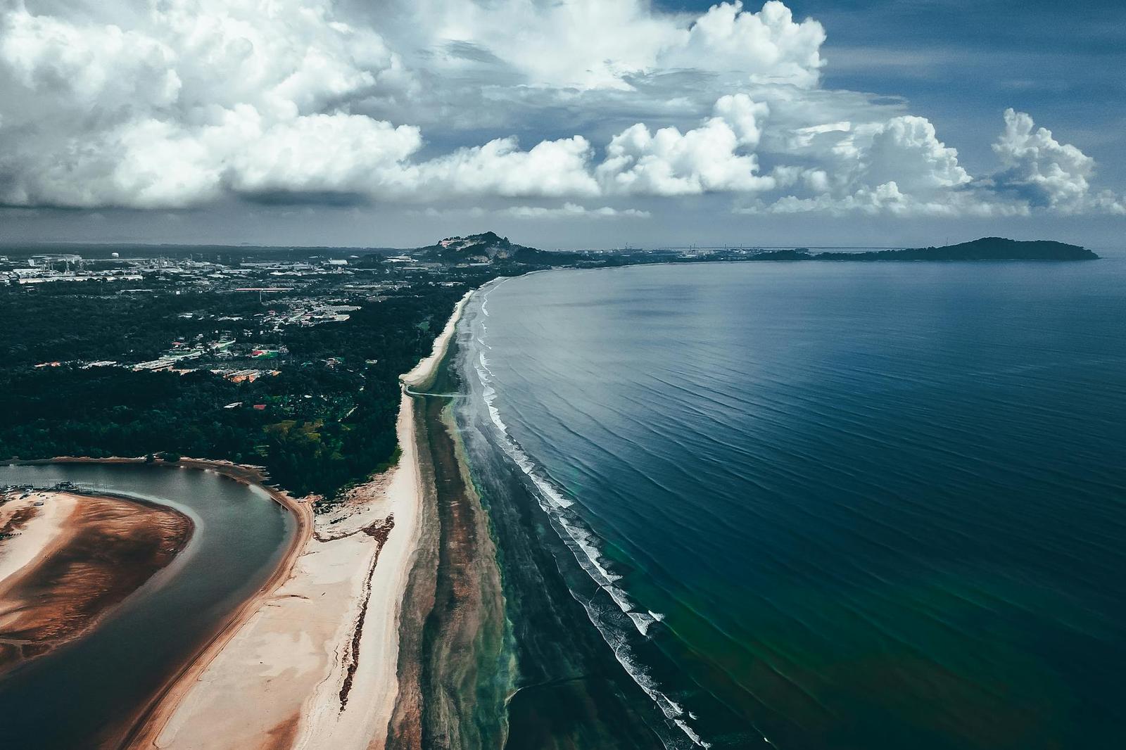 Aerial view of a river mouth meeting a forested coastline