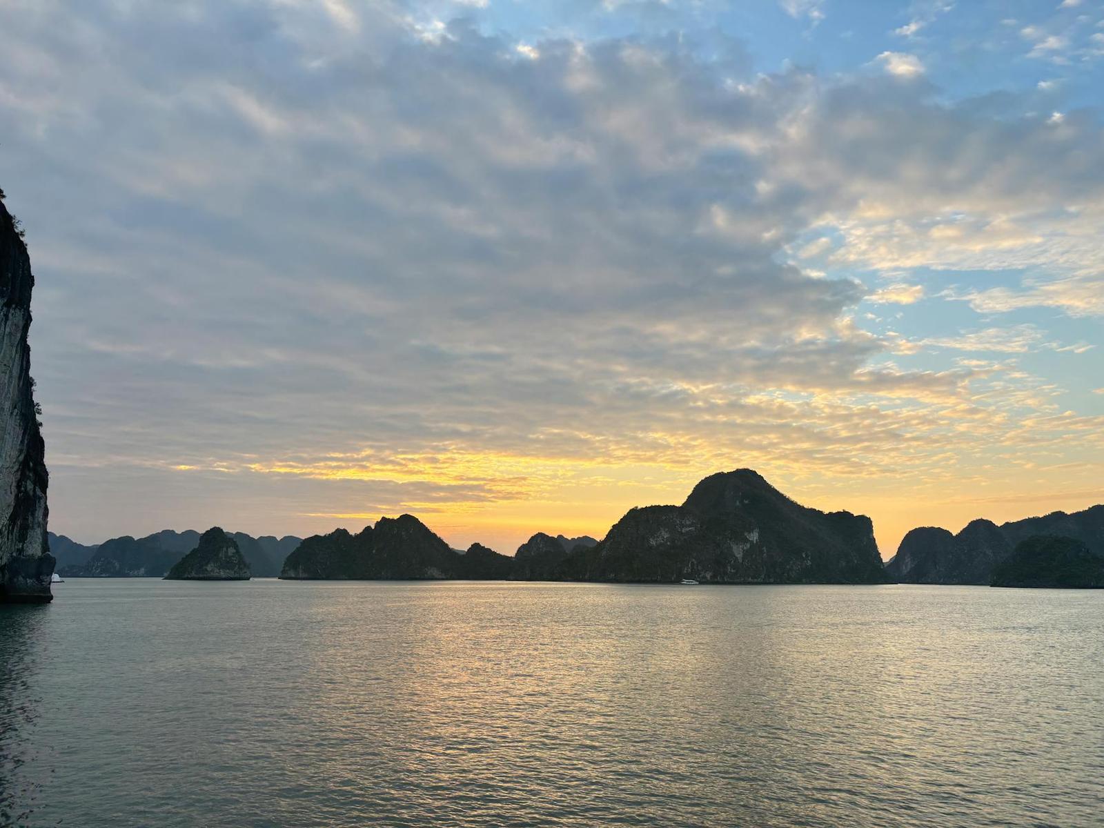 Tranquil sunset view of Halong Bay with scenic limestone islands and calm waters