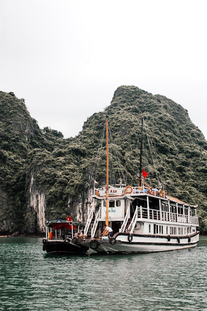 Tour boat anchored beside towering limestone karsts