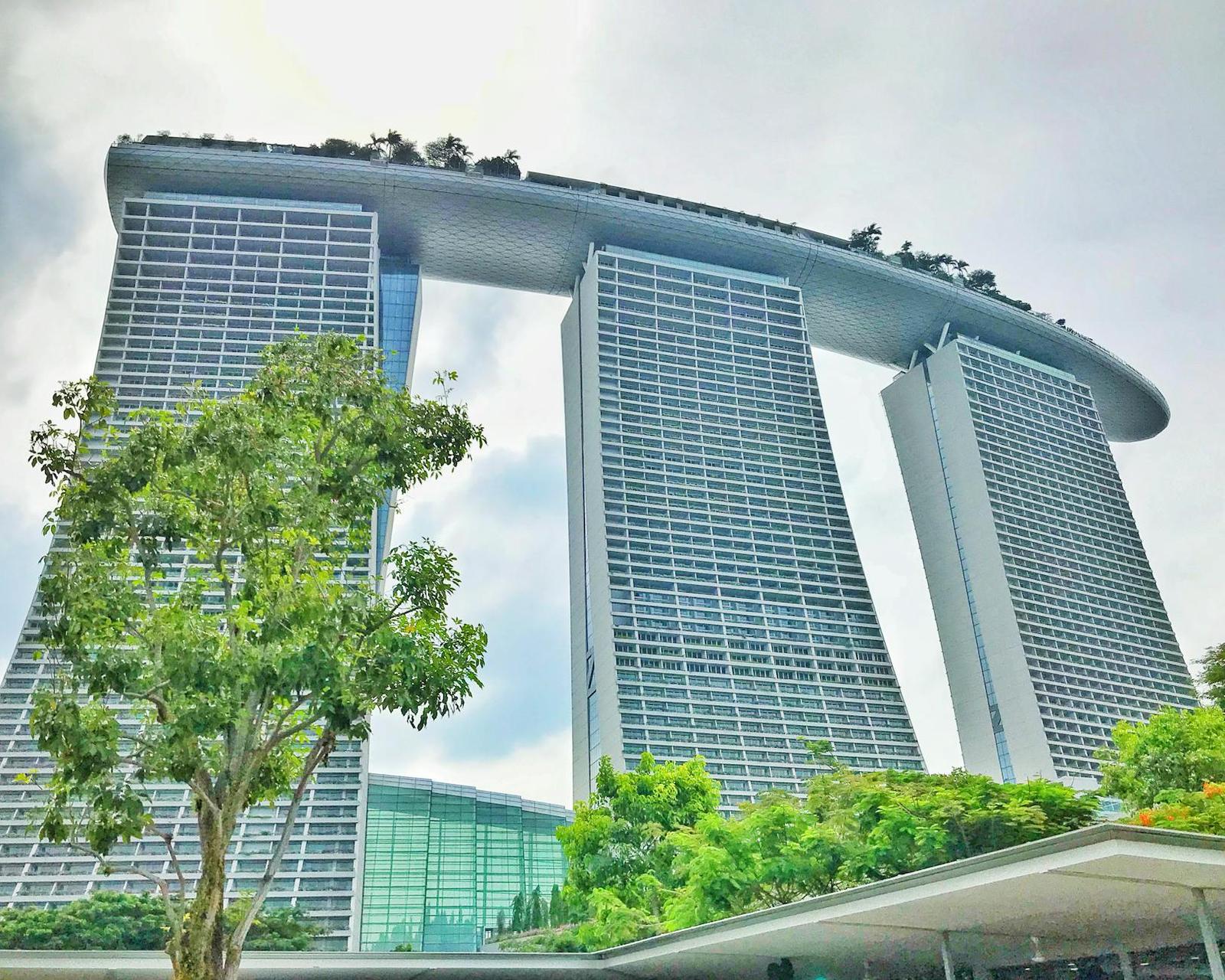 Marina Bay Sands' three towers topped with a sweeping rooftop garden against clouds