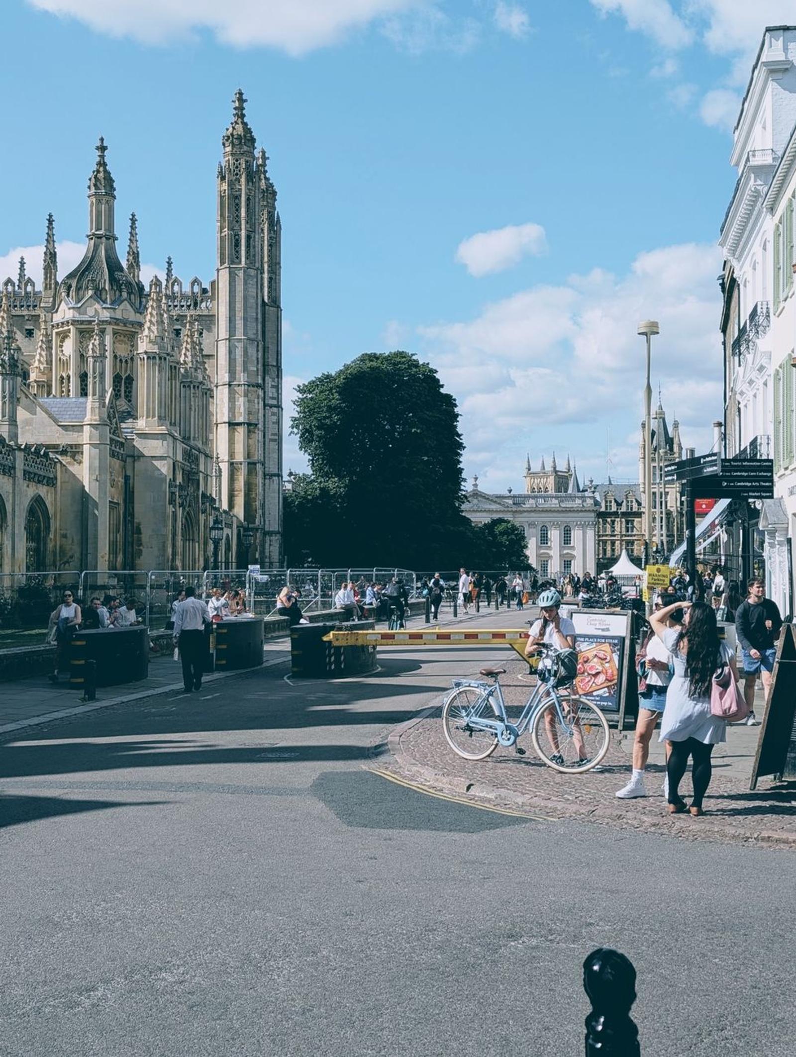 Bicycle parked on a college street with a gothic tower behind