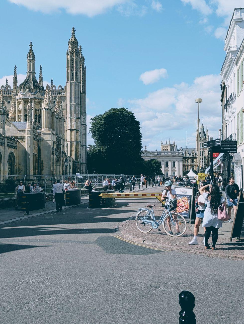 Bicycle parked on a college street with a gothic tower behind