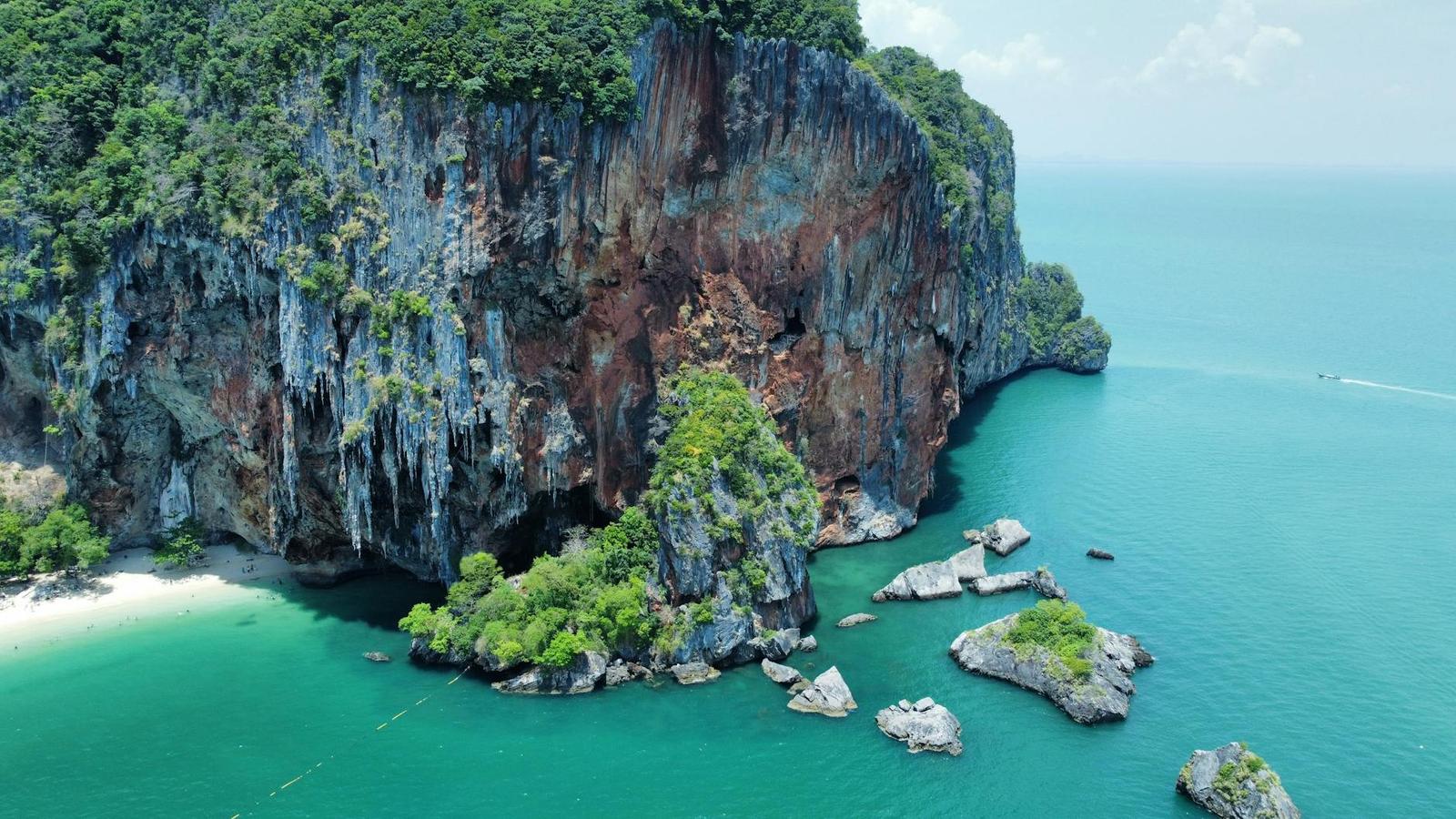 Sheer limestone cliffs rising from turquoise water dotted with small rock islets