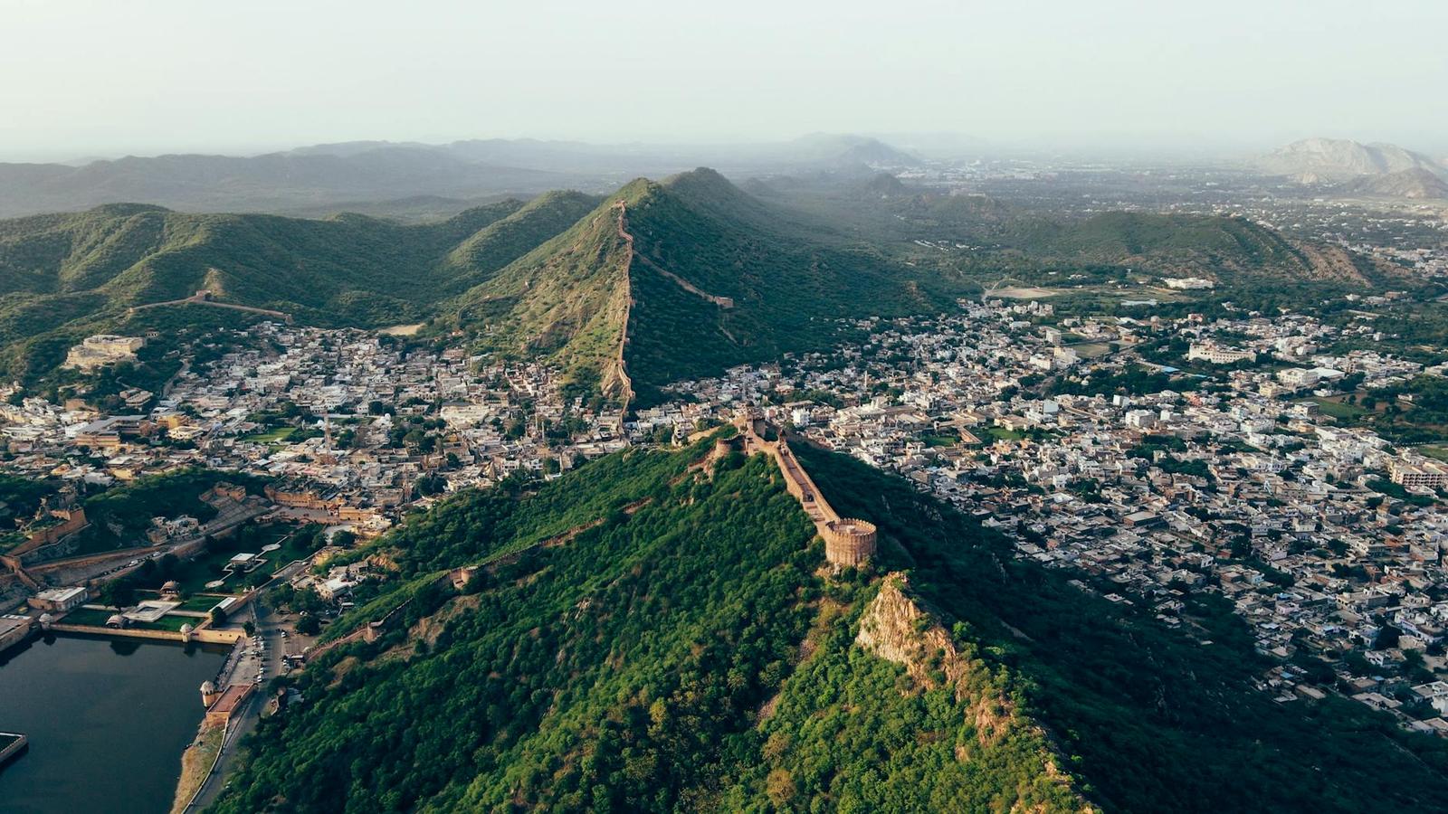 Aerial view of a fortified wall running along a forested ridge above a town