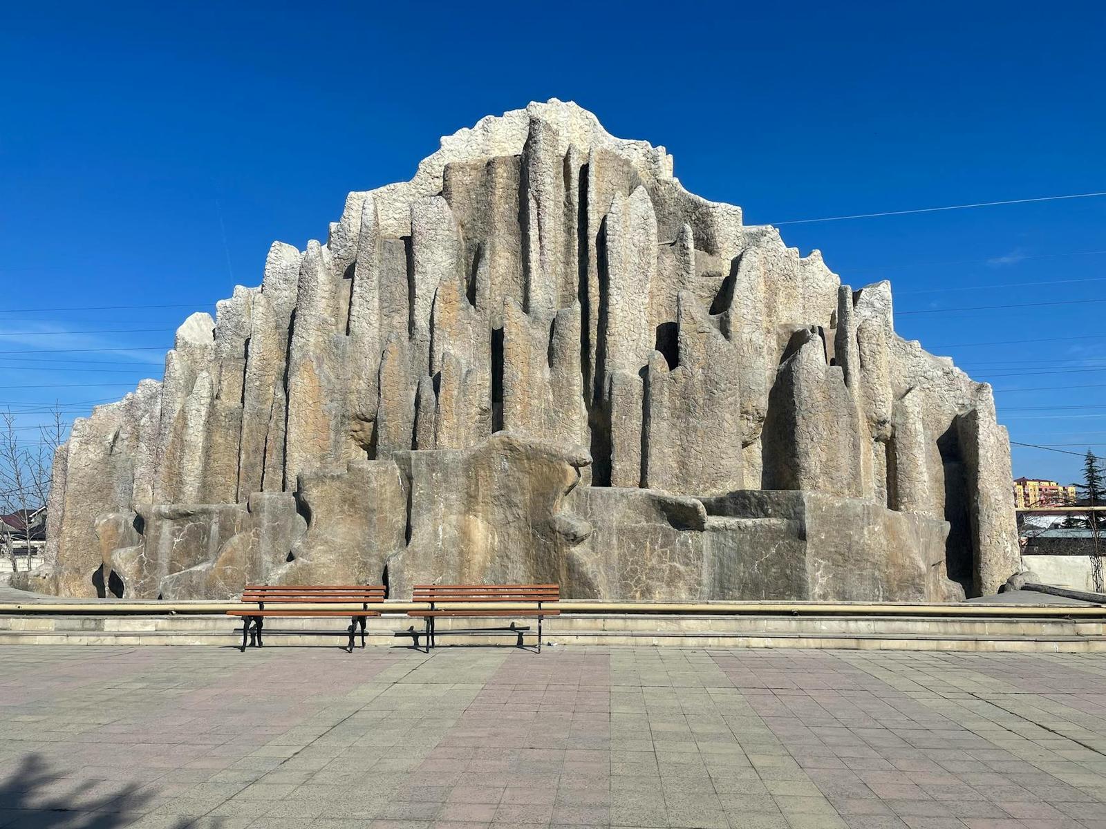 Majestic rock formation resembling basalt columns under a clear blue sky