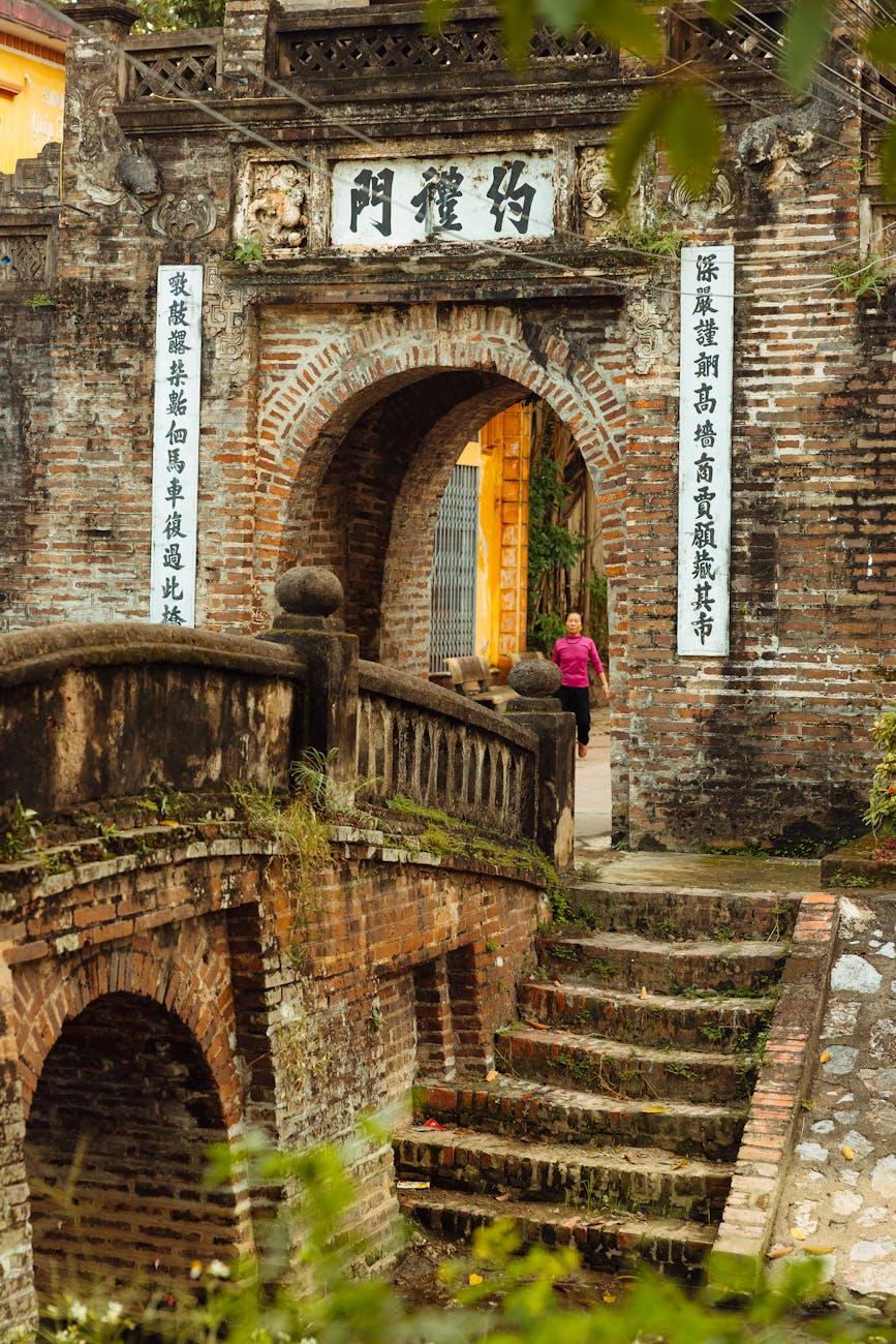 Historic Vietnamese gate and brick bridge capturing traditional architecture and cultural heritage