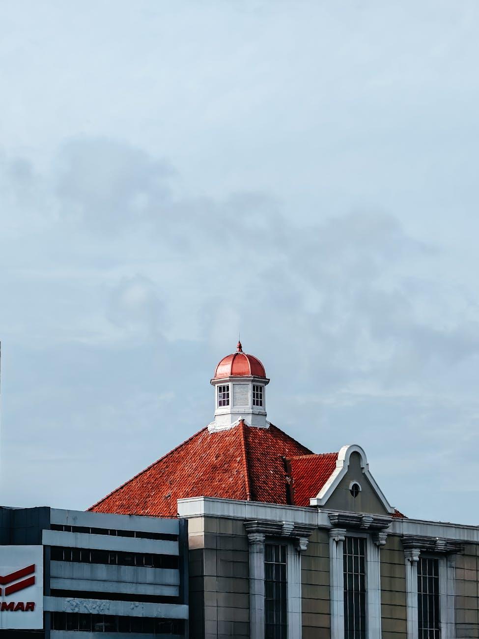 A stunning view of a historic building with a red dome roof in Jakarta under a clear sky
