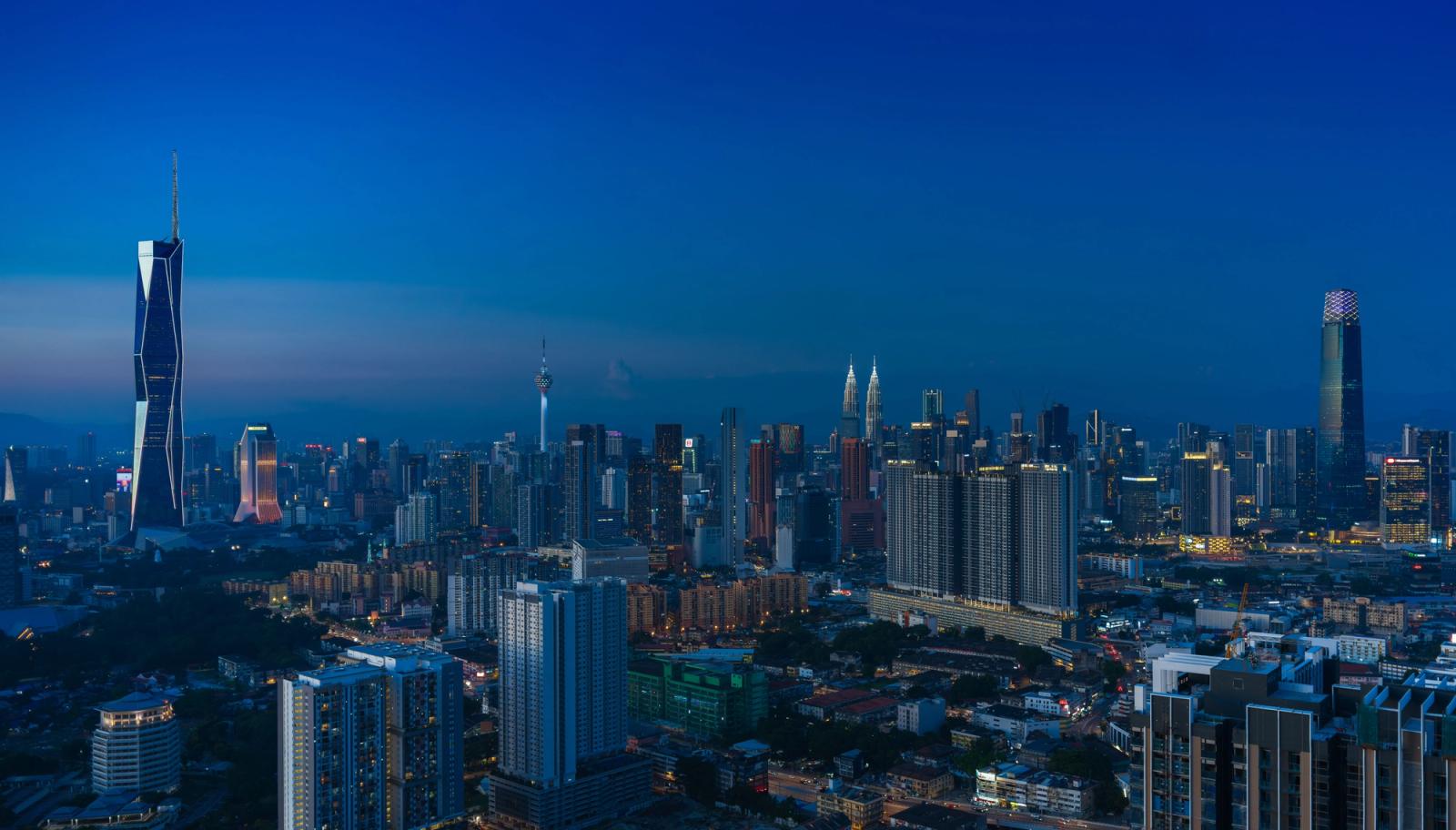 Discover the vibrant Kuala Lumpur skyline featuring iconic landmarks in the evening glow