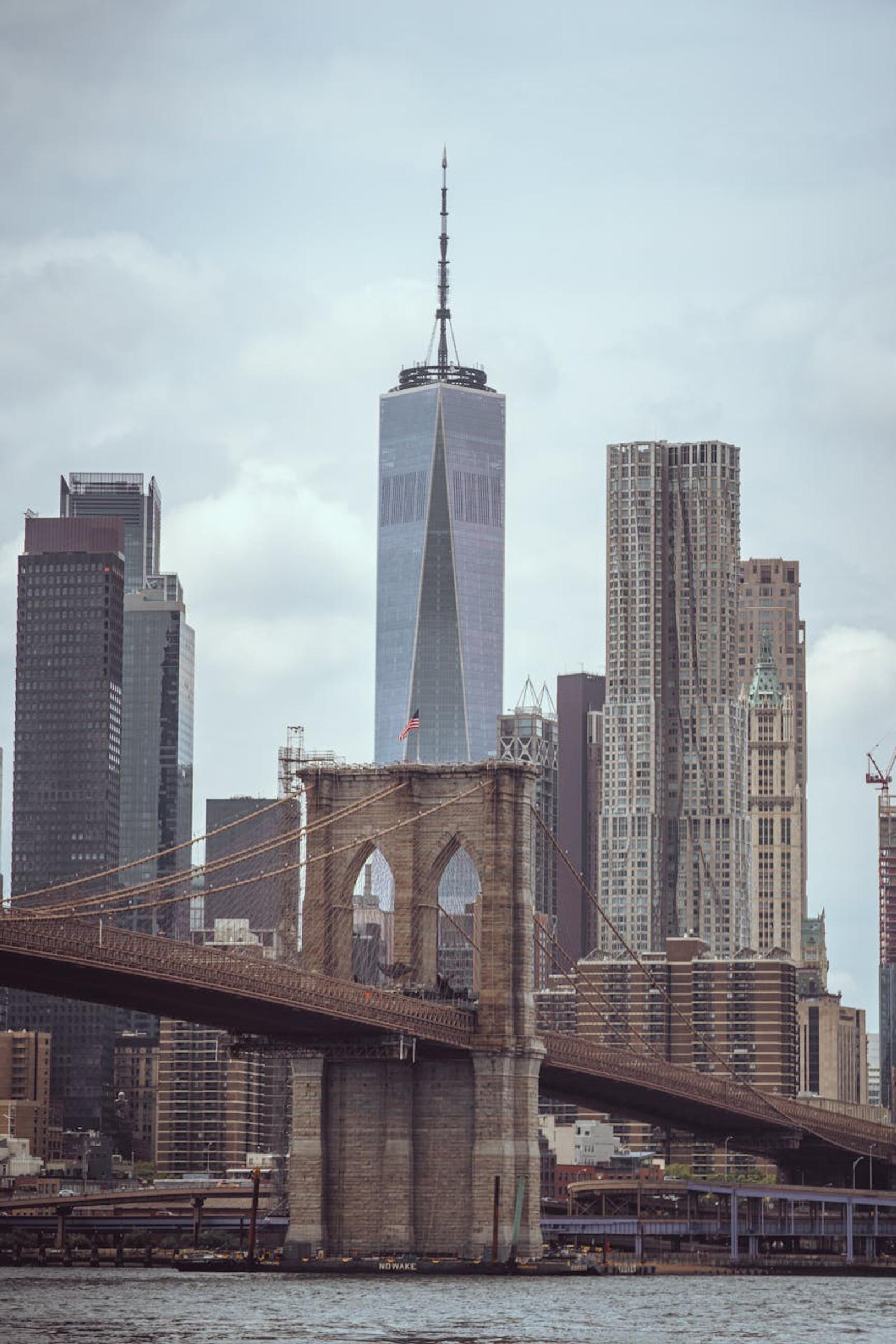 Suspension bridge stone tower framed against a modern skyline