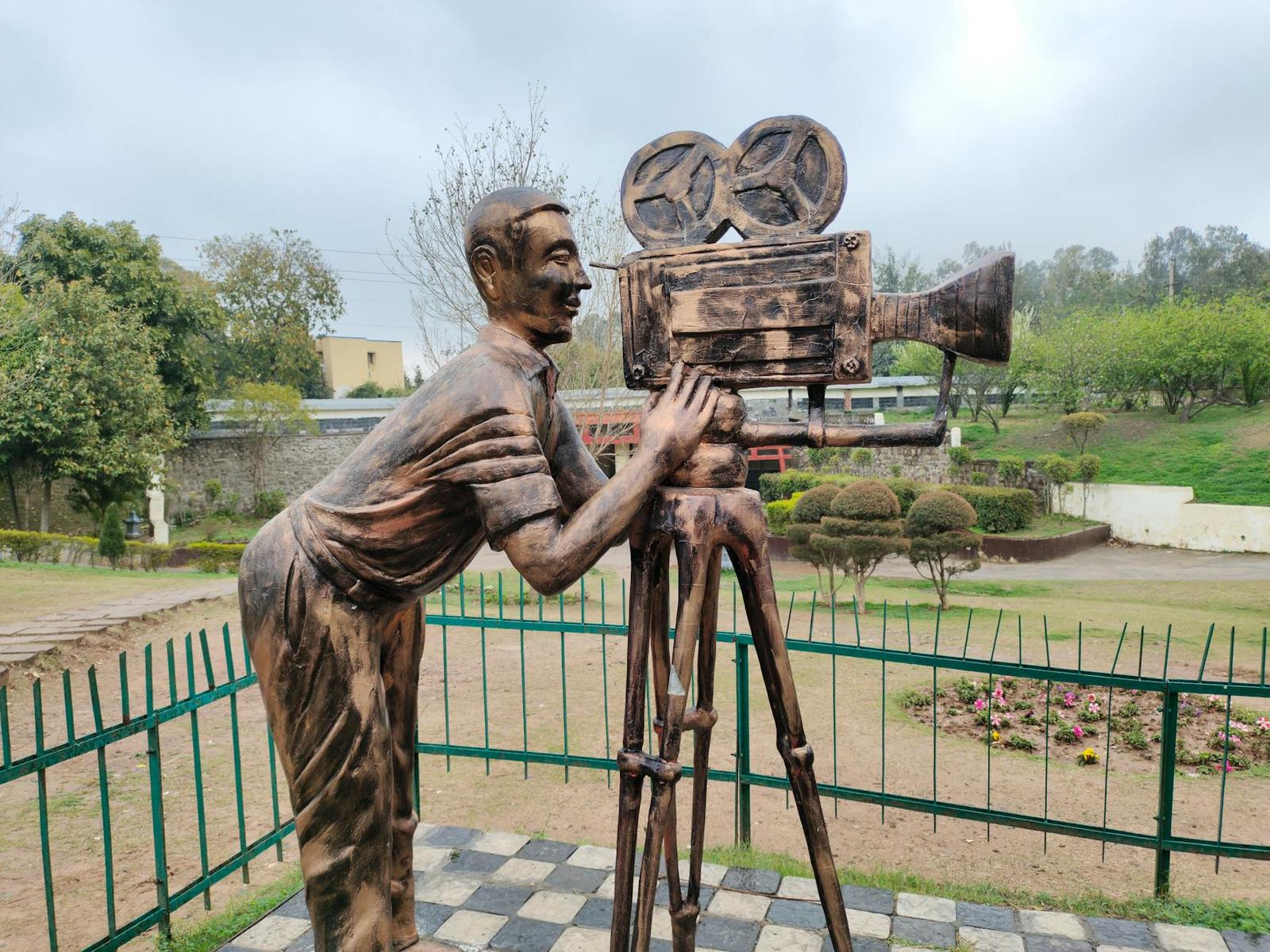 Bronze sculpture of a cameraman with classic camera in a park in Chandigarh, India