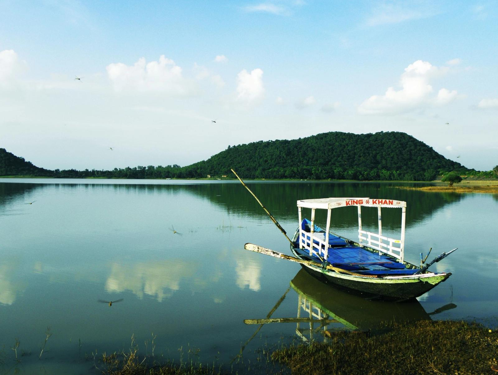 Tranquil view of a traditional boat on a serene lake in Jharkhand, India