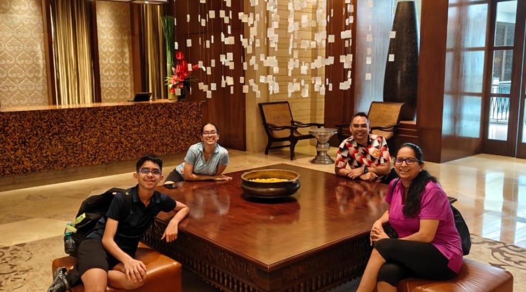 Four people seated around a large wooden table