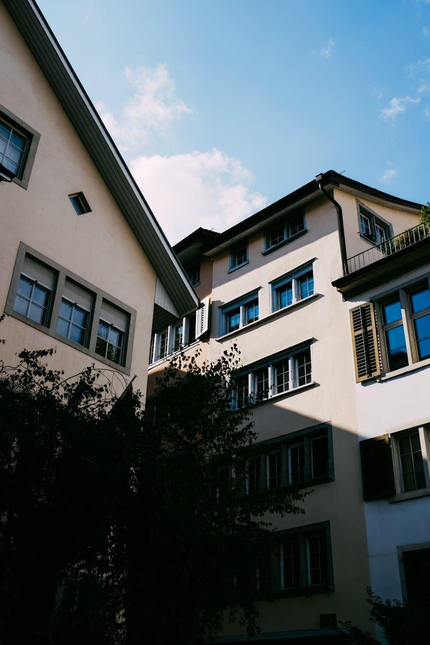 Upward view of pastel townhouse facades against a clear sky