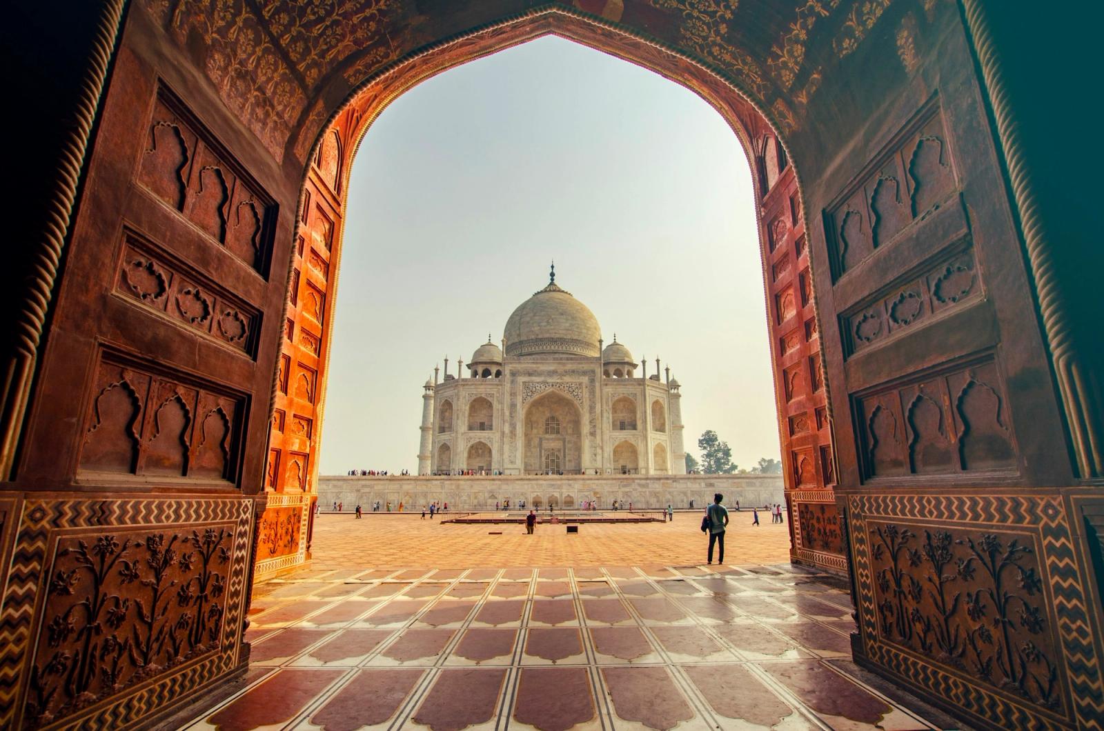 Taj Mahal framed in a sandstone gateway at golden hour