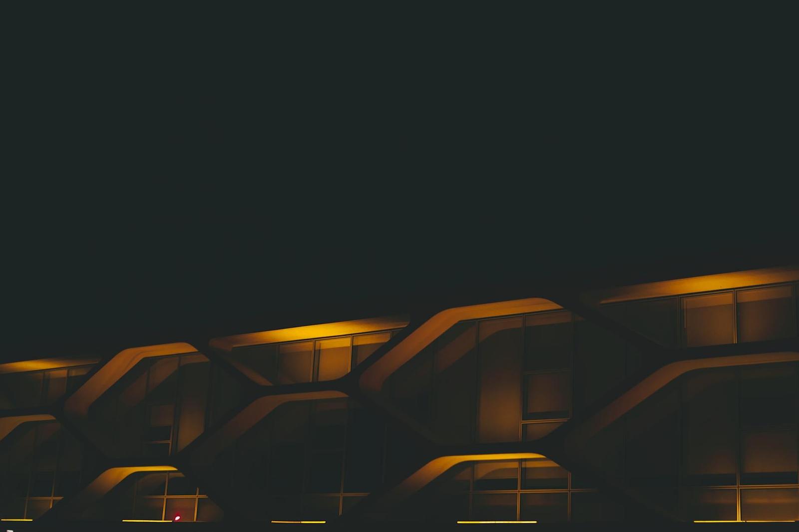 Illuminated honeycomb-patterned building facade at night