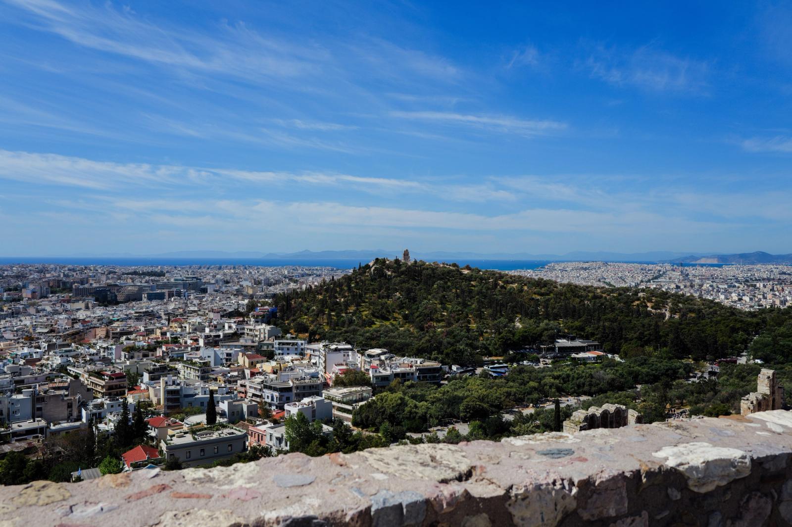 Panoramic view of Athens cityscape with iconic Lycabettus Hill, under clear blue skies