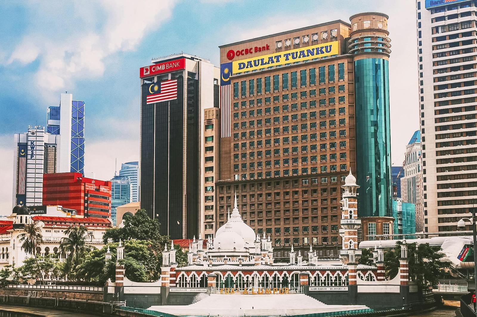 A domed building in front of tall bank and office towers under a cloudy sky