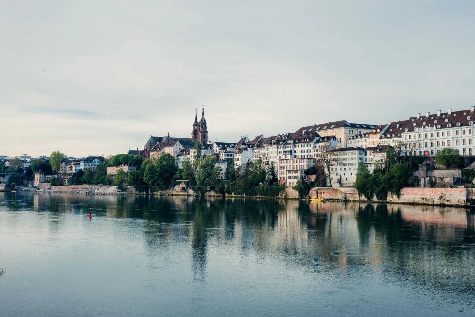 Charming riverfront view of Basel, Switzerland, showcasing historic architecture along the Rhine River