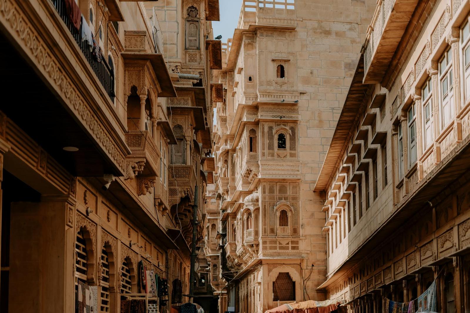 A narrow desert-town alley flanked by carved sandstone havelis with balconies