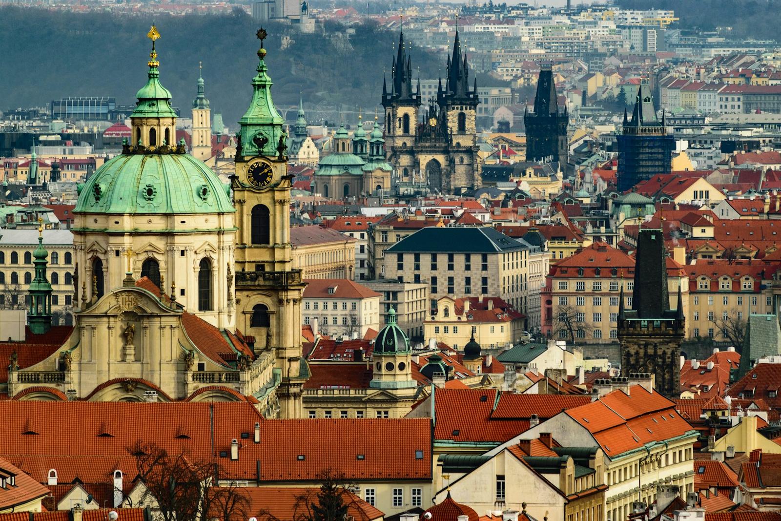 Prague's old-town spires and Charles Bridge over the Vltava at dusk