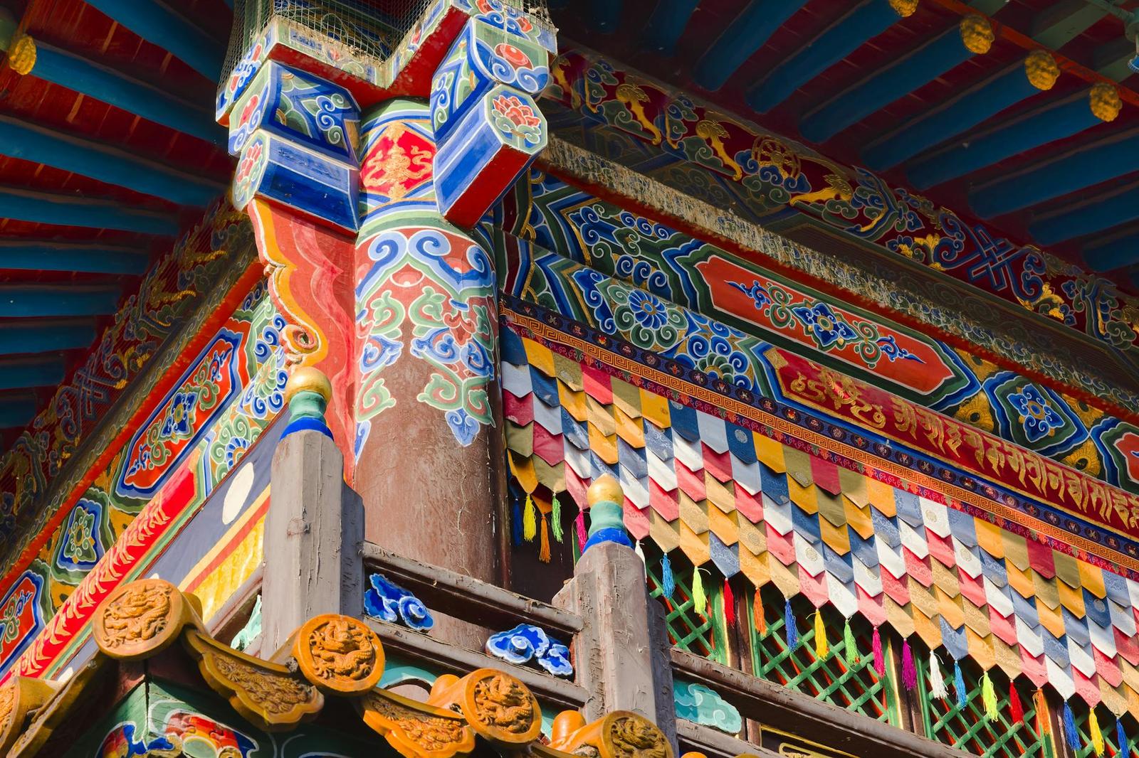 Close-up of ornately painted temple eaves with colourful carved beams