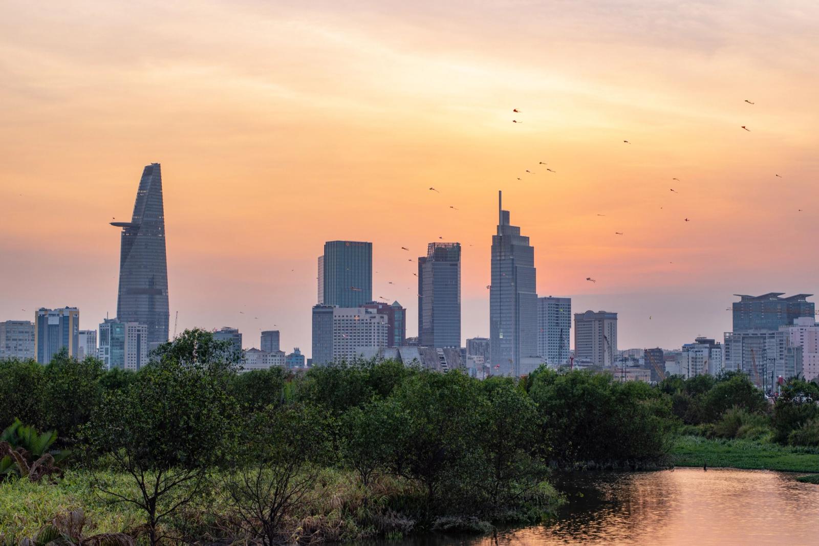 A scenic view of the Ho Chi Minh City skyline with a stunning sunset backdrop