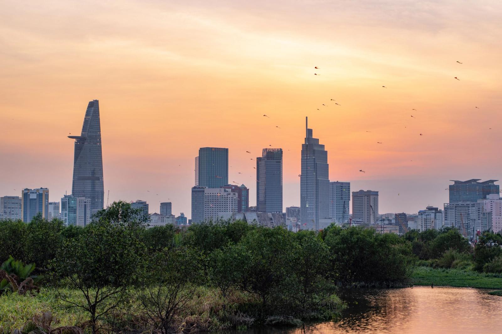 A scenic view of the Ho Chi Minh City skyline with a stunning sunset backdrop
