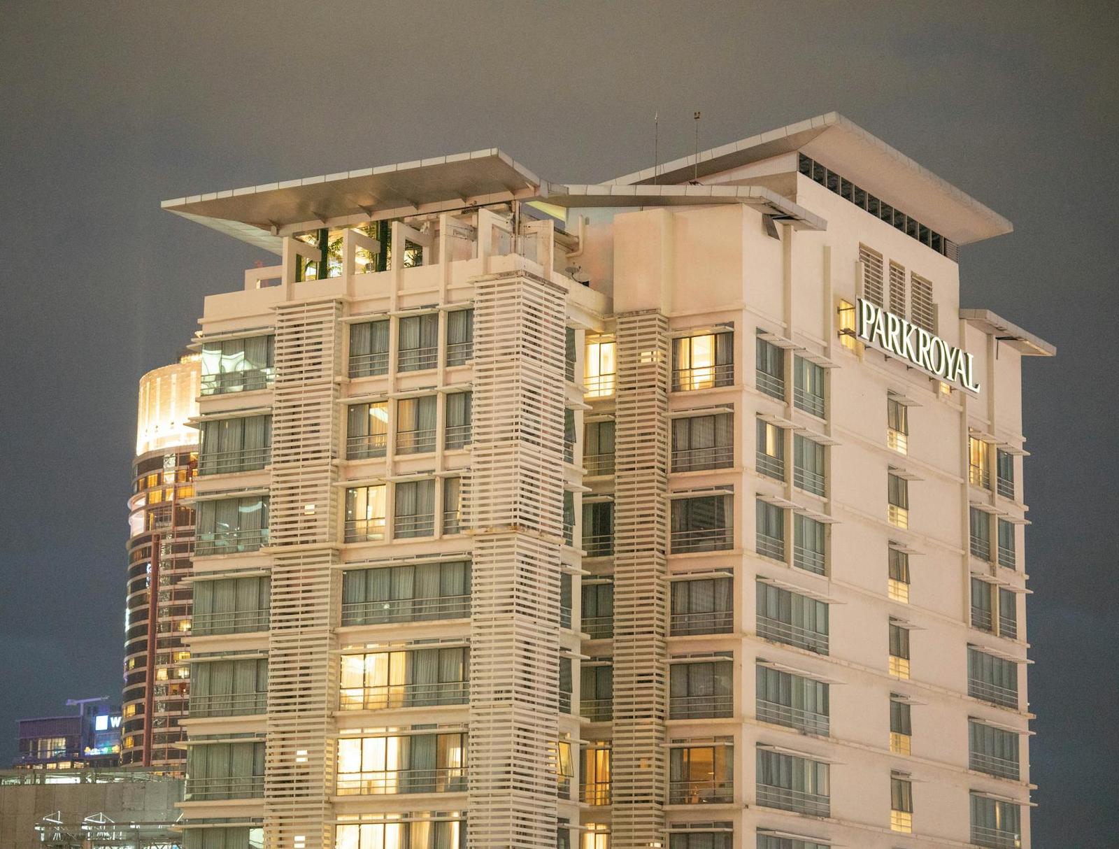 A tall branded hotel tower lit up against a night sky