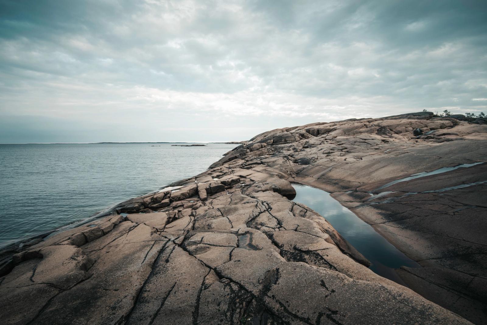 Captivating view of expansive rocky shoreline meeting a serene sea under a moody sky
