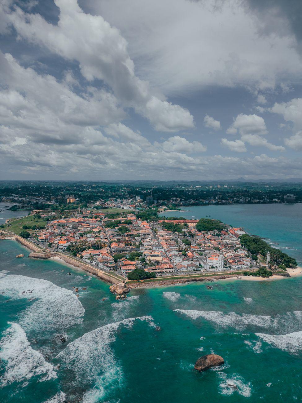 Aerial view of a historic seaside town jutting into the ocean