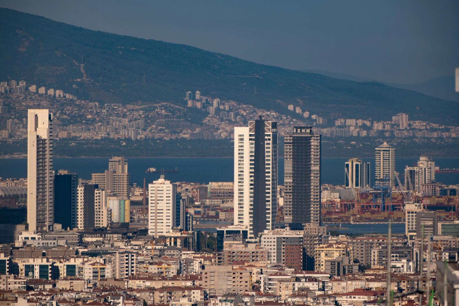 Captivating aerial cityscape of İzmir, Turkey, showcasing modern skyscrapers against a mountainous backdrop