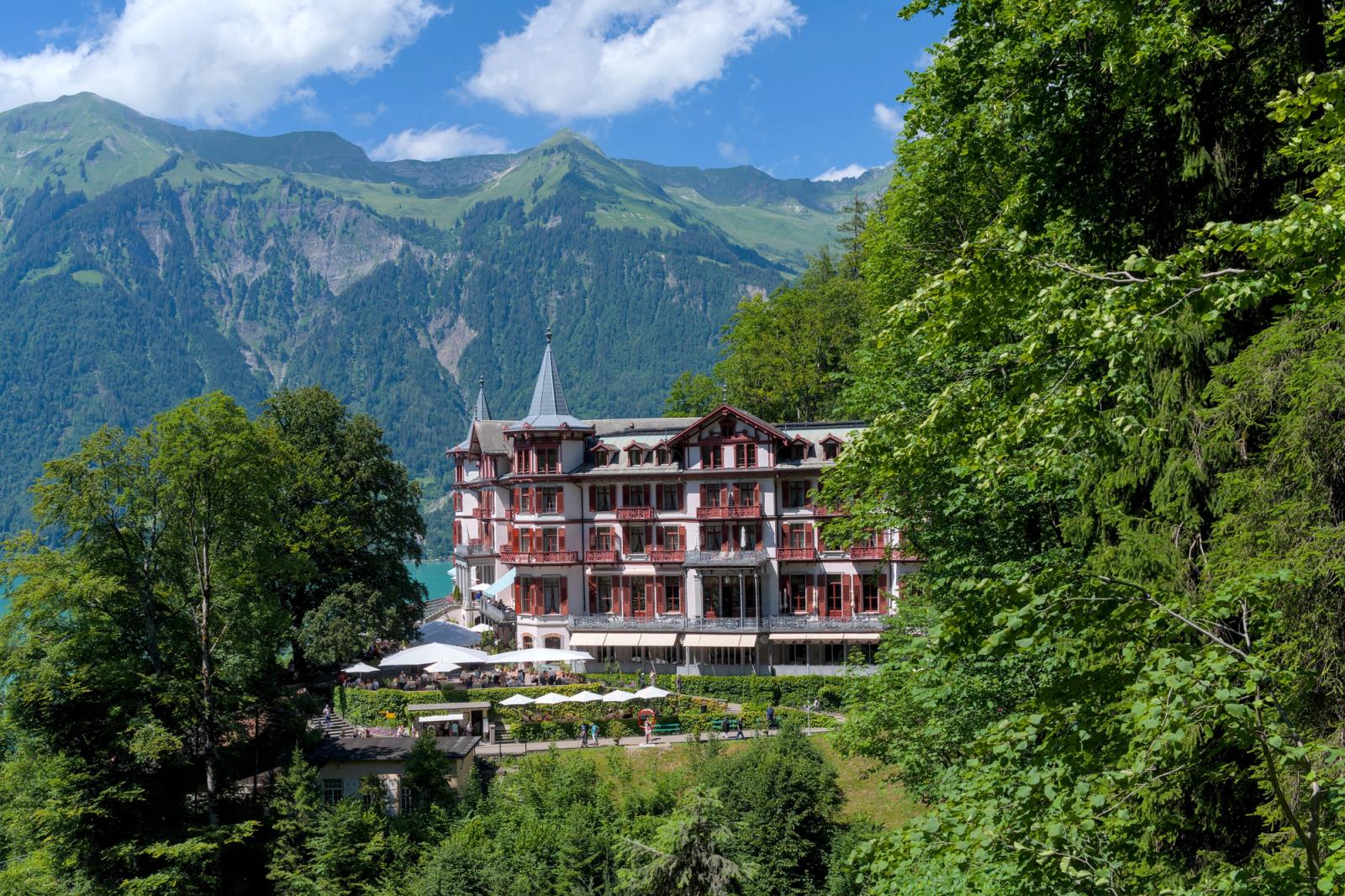 Elegant Swiss hotel nestled in lush greenery and mountains of Brienz, showcasing serene landscapes and alpine architecture