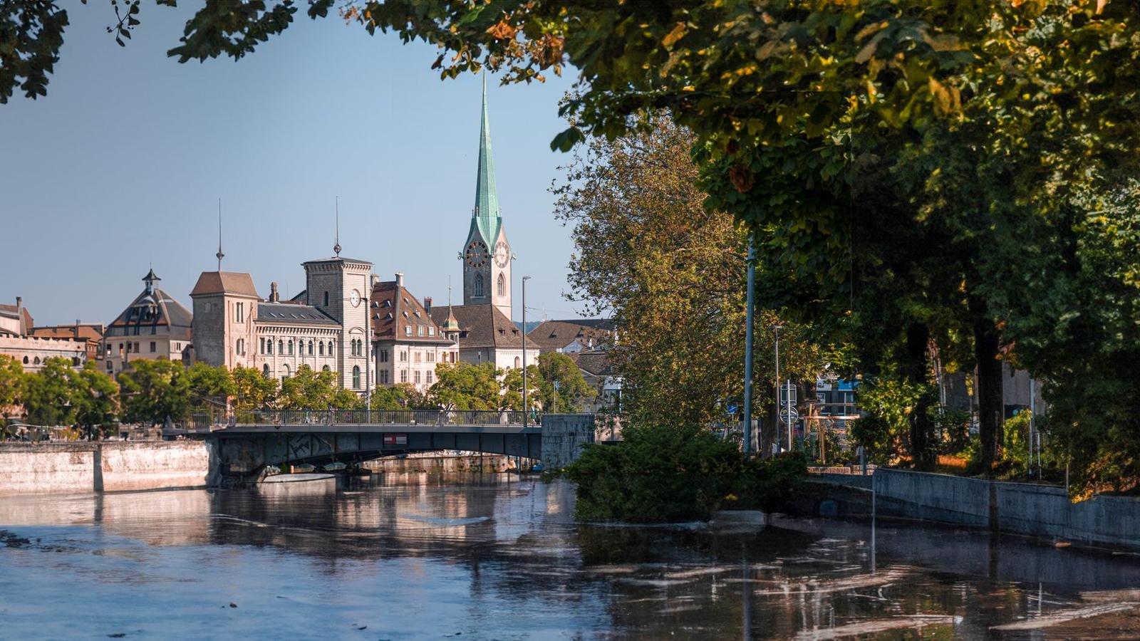 Beautiful view of Zurich, Switzerland, featuring Fraumünster Church and Limmat River on a sunny day