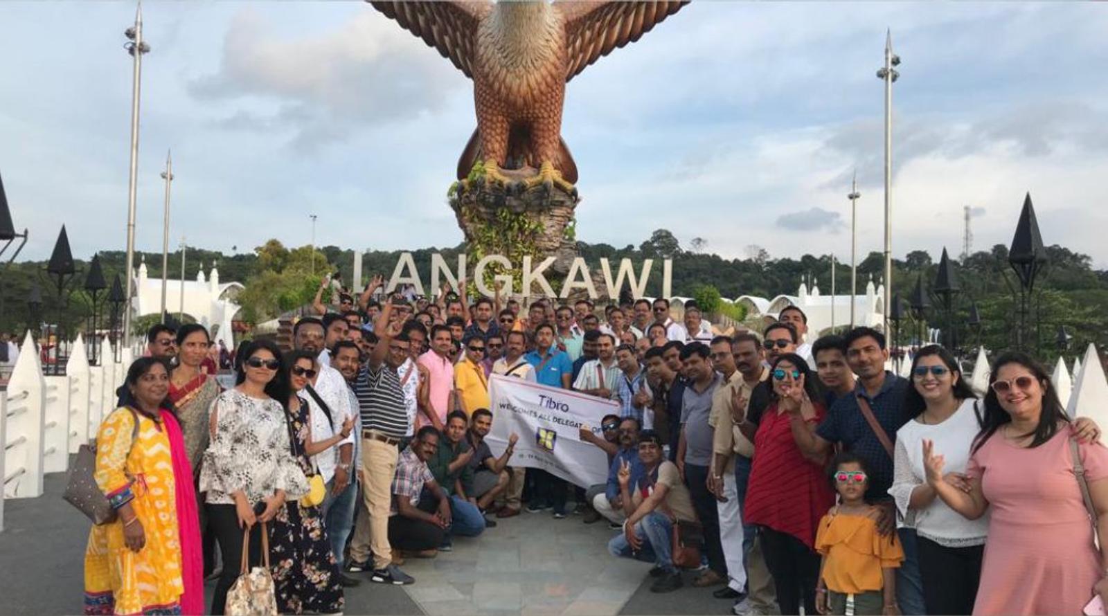 A large group posing in front of the Langkawi Eagle Square statue.