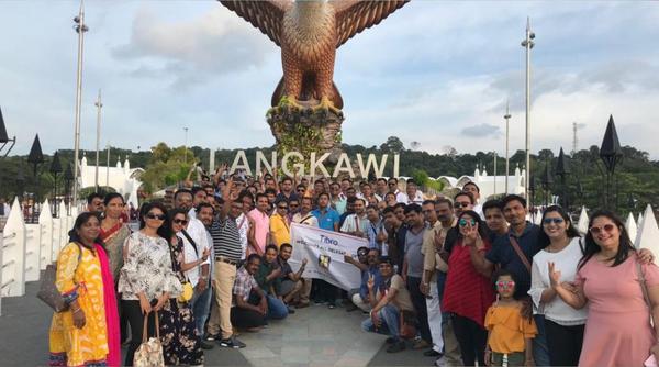 A large group posing in front of the Langkawi Eagle Square statue.