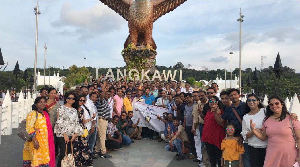 A large group posing in front of the Langkawi Eagle Square statue.