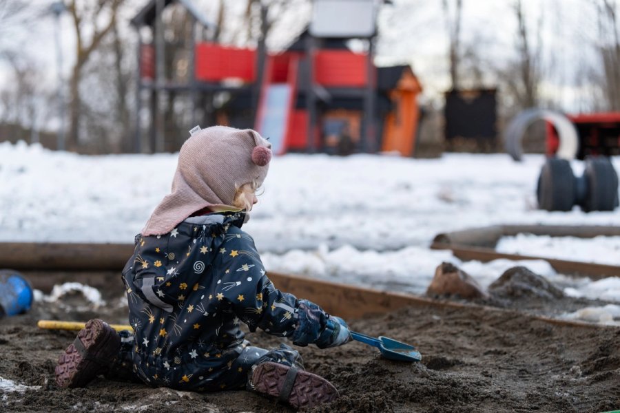 Foto av et barn som leker ute i sandkassen.